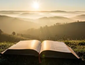 Peaceful sunrise with open Bible representing new life through the Holy Spirit from Romans 8:5-11.